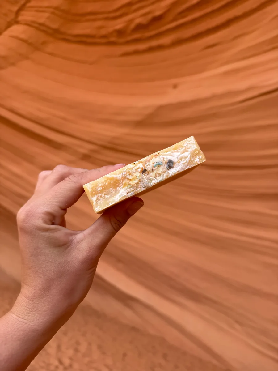 Handmade bar soap, honey gold with embedded botanicals, canyon behind