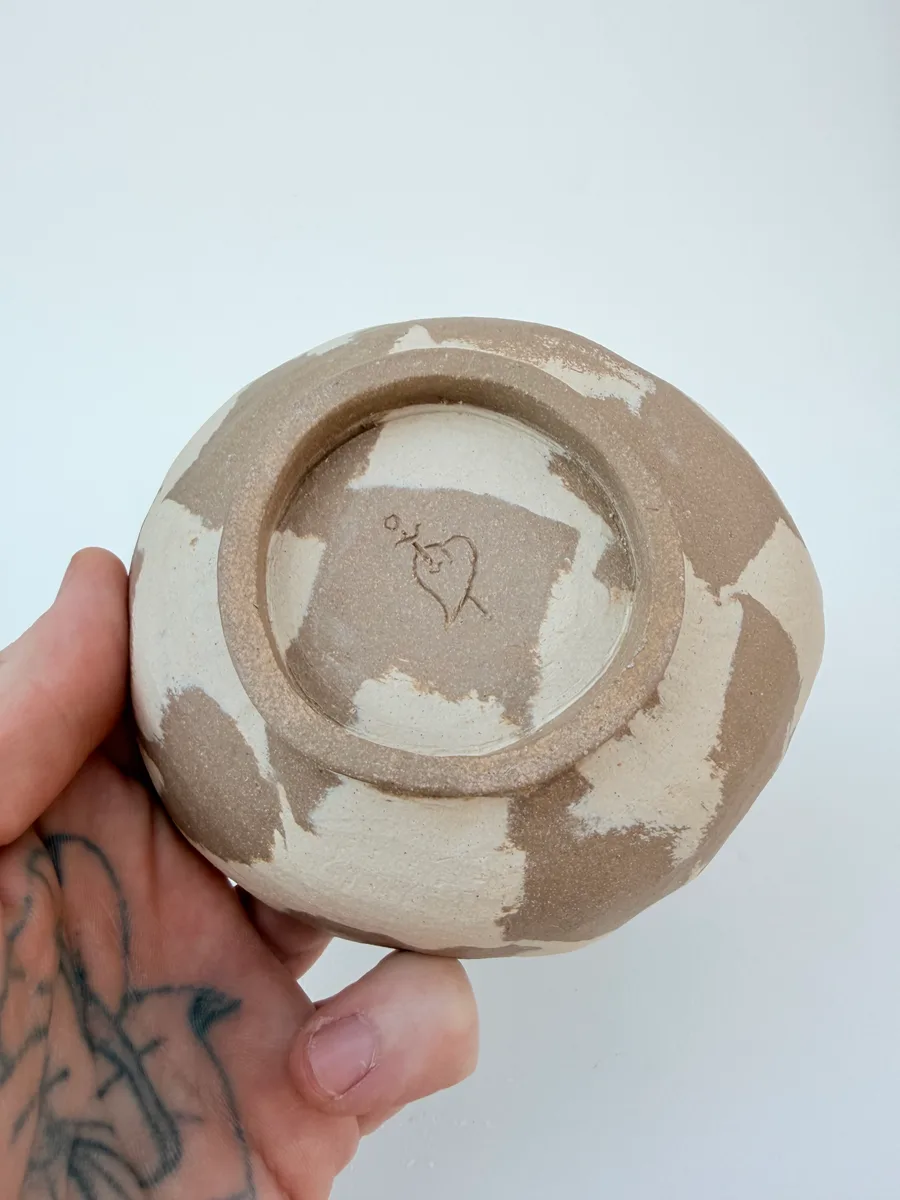Jake's hands shaping a piece on the wheel