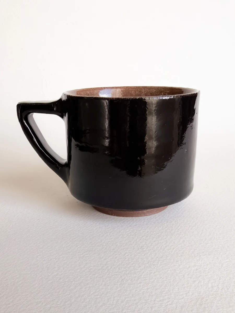 Small glossy black seven-sided mug