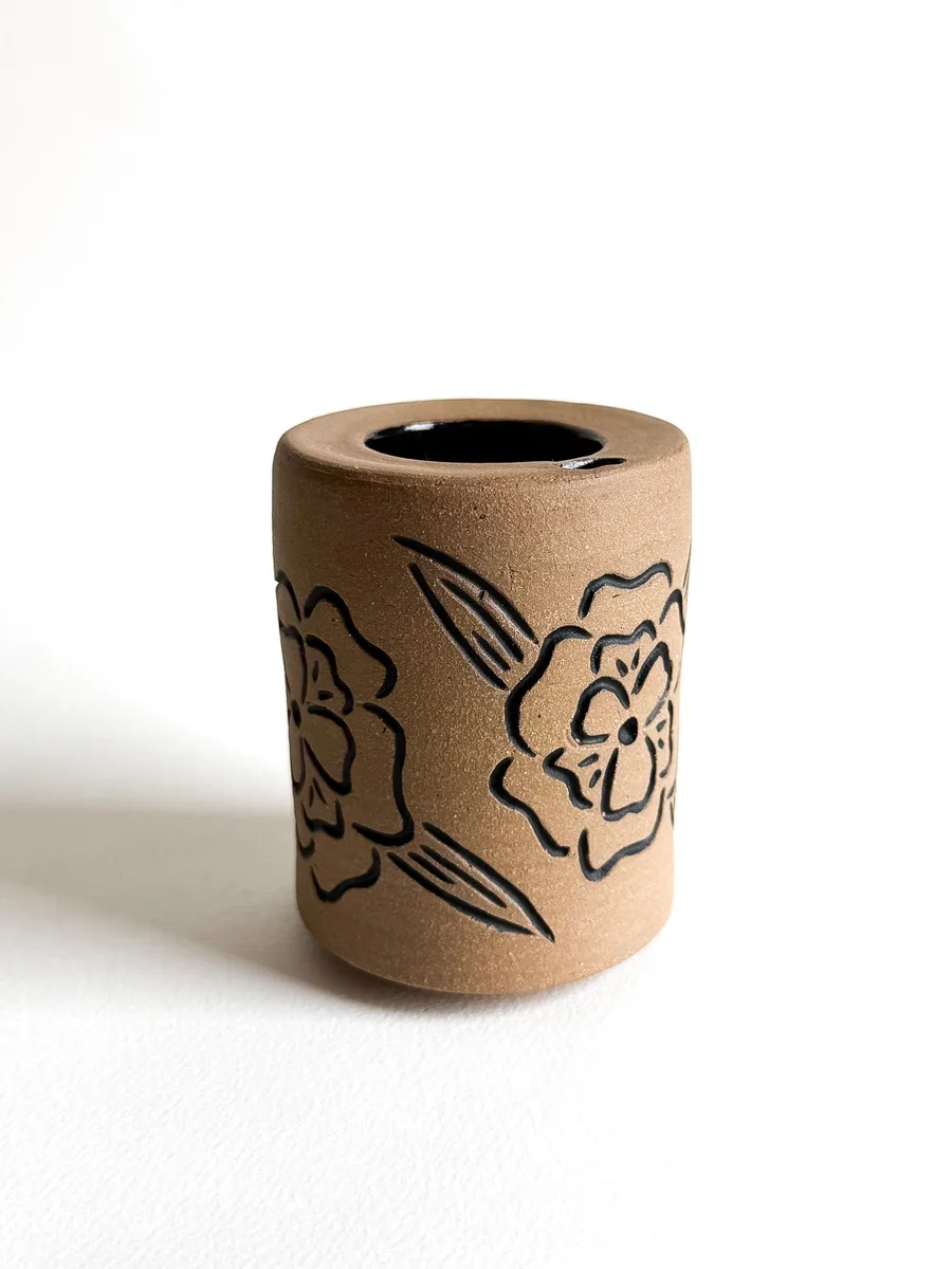 Travel cup with a hand-carved flower design