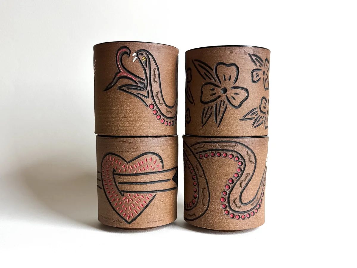Flash cups carved with traditional tattoo motifs