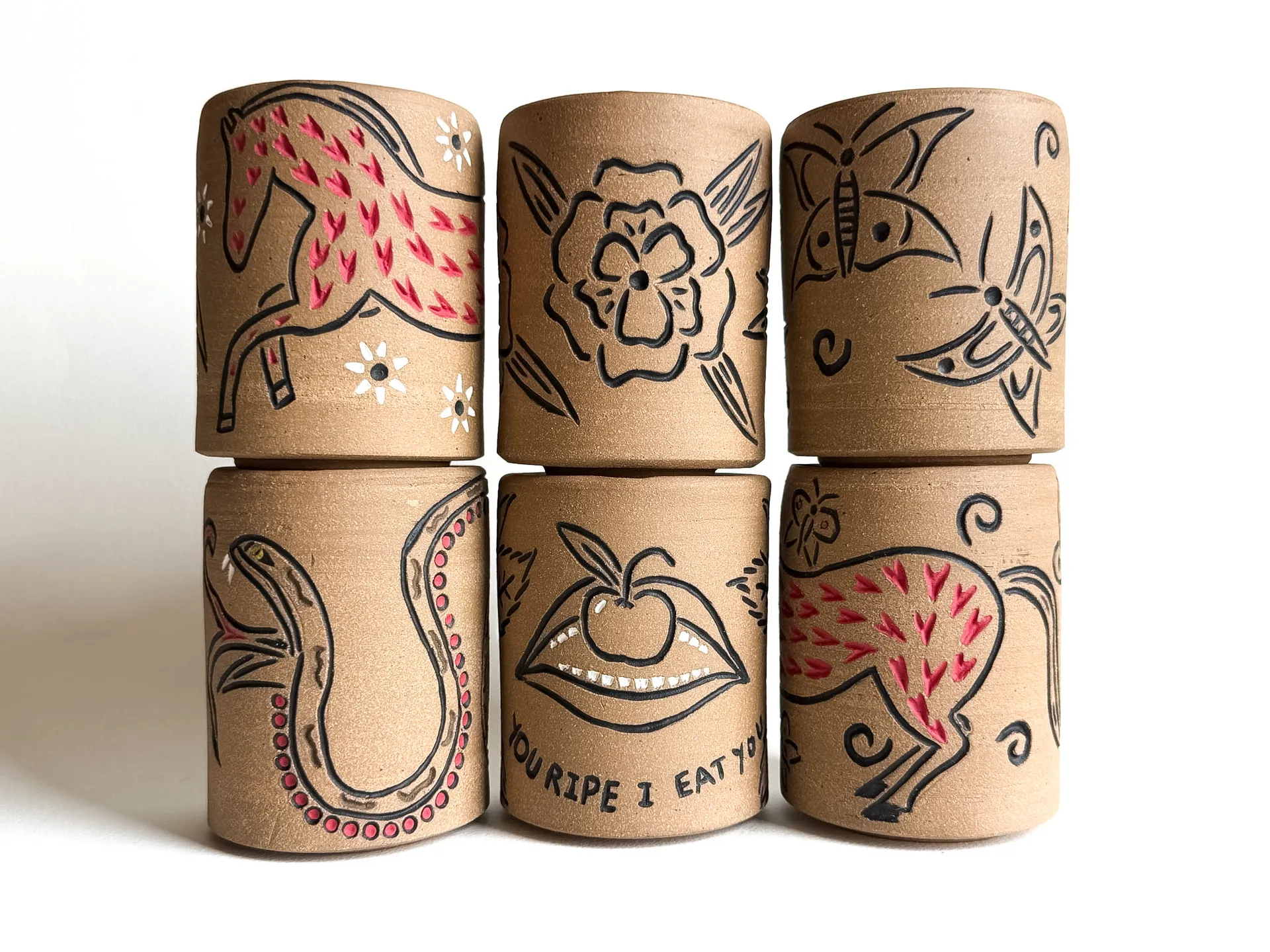 A group of carved travel cups with quarter lids