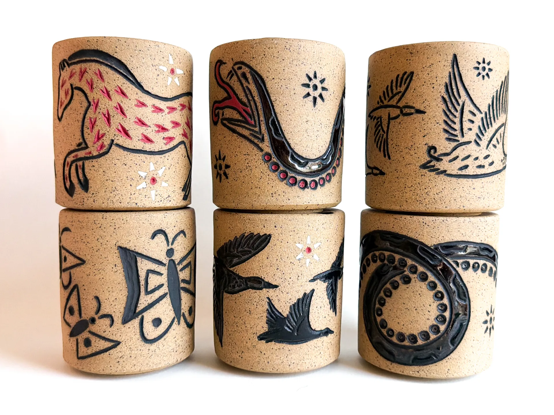 Travel cup with a hand-carved snake wrapping the raw speckled clay body
