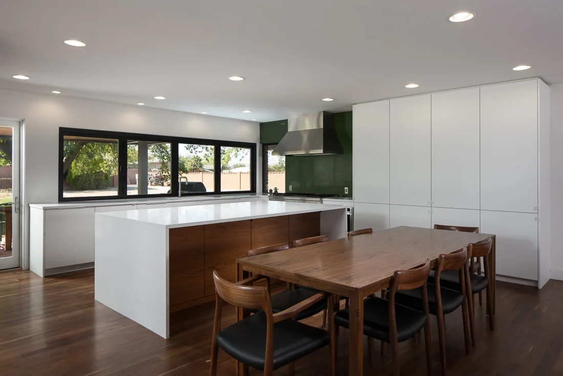 Kitchen with white cabinetry and wood dining table; Southern Utah residential design and remodeling